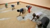 FILE - Women sweep rice at a small processing plant in the northern Ghanaian town of Bolgatanga, Feb. 1, 2008. 