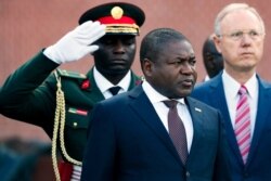 FILE - Mozambique President Filipe Nyusi, center, visits the Tomb of the Unknown Soldier in central Moscow, Aug. 21, 2019.