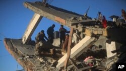 FILE - Palestinians inspect the damage of a destroyed house following Israeli airstrikes on Khan Younis, Southern Gaza Strip, January 7, 2024.