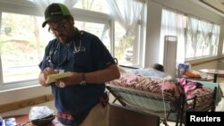 Dr. Carlos Mellado reviews prescriptions of patients in a public shelter in Orocovis, Puerto Rico, Oct. 3, 2017. 