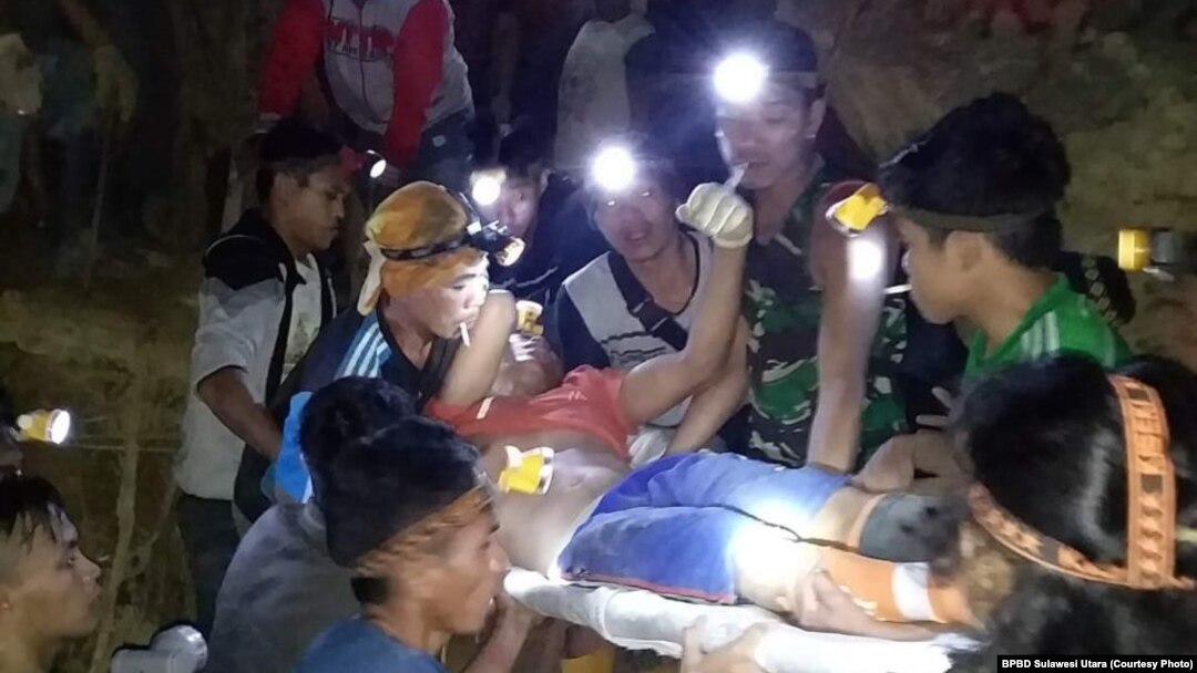 Tim BPBD, polisi, PMI dan warga bahu-membahu melakukan evakuasi untuk menyelamatkan sekitar 60 penambang yang masih terperangkap di dalam lubang galian penambangan emas ilegal di Bolaang Mongondow, Sulawesi Utara, Rabu pagi, 27 Februari 2019. (Foto: BPBD