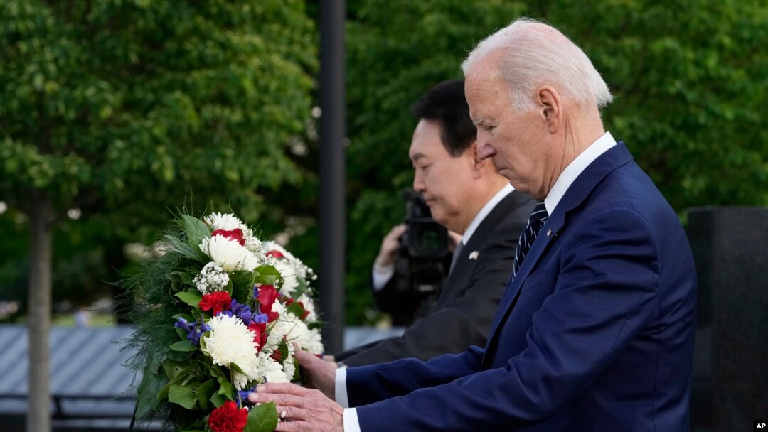 Presiden AS Joe Biden dan Presiden Korea Selatan Yoon Suk Yeol meletakkan karangan bungan dalam kunjungan mereka ke tugu peringatan Veteran Perang Korea di Washington, pada 25 April 2023. (Foto: AP/Susan Walsh)