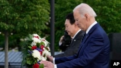 Presiden AS Joe Biden dan Presiden Korea Selatan Yoon Suk Yeol meletakkan karangan bungan dalam kunjungan mereka ke tugu peringatan Veteran Perang Korea di Washington, pada 25 April 2023. (Foto: AP/Susan Walsh)