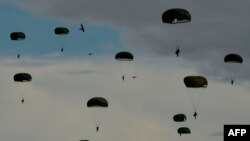Indonesian paratroopers come down with their chutes during the Jalak Sakti military exercise held at the Sultan Iskandar Muda Air Force Base in Blang Bintang, Aceh province.