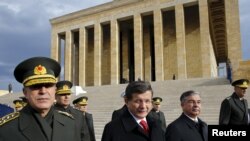 Perdana Menteri Turki Ahmet Davutoglu, kedua dari kiri, diapit oleh jenderal-jenderal Turki, meninggalkan upacara peletakan karangan bunga di Anitkabir, makam pendiri Turki modern Mustafa Kemal Ataturk, di Ankara, Turki, 26 November 2015. 