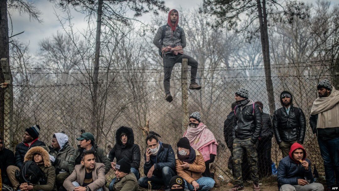 Migrants wait near a buffer zone at the Turkey-Greece border, at Pazarkule, in Edirne district, Feb. 29, 2020. Thousands of migrants stuck on the border clashed with Greek police Saturday, according to an AFP photographer at the scene.