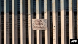 En la foto de archivo se ve un letrero en la frontera entre Estados Unidos y México que dice en español "todos somos migrantes", en Playas de Tijuana, noroeste de México.