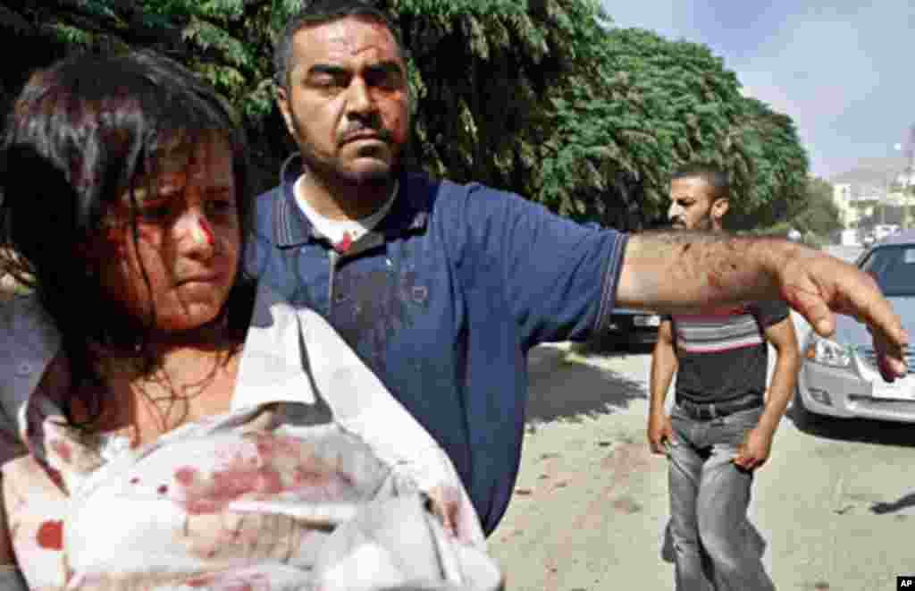 Injured Syrians arrive at a field hospital after an air strike hit their homes in the town of Azaz on the outskirts of Aleppo, Syria, Aug. 15, 2012.