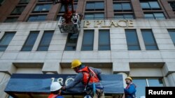 Fəhlələr Manhattanın Upper West Side məhəlləsində Trampın adını binanın üzərindən qoparırlar. Nyu York, ABŞ. 16 noyabr, 2016 REUTERS/Brendan McDermid