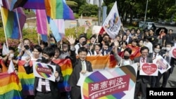 People including plaintiffs' lawyers hold banners and flags, after the lower court ruled that not allowing same-sex marriage was unconstitutional, outside Nagoya district court, in Nagoya, central Japan, May 30, 2023, in this photo released by Kyodo. Kyodo via REUTERS
