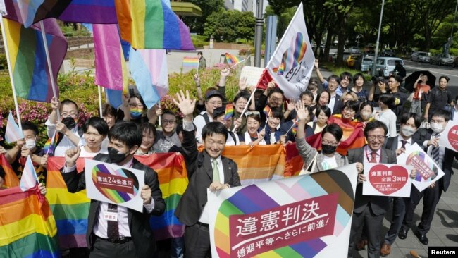 People including plaintiffs' lawyers hold banners and flags, after the lower court ruled that not allowing same-sex marriage was unconstitutional, outside Nagoya district court, in Nagoya, central Japan, May 30, 2023, in this photo released by Kyodo. Kyodo via REUTERS