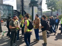 Yellow vest protesters wait near the Seine River for other members to join them, Sept. 7, 2019. (L. Bryant/VOA)