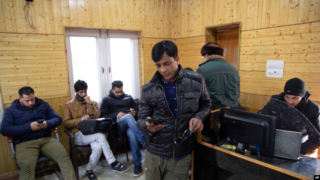 FILE - Kashmiri journalists browse the internet on their mobile phones inside the media center set up by government authorities in Srinagar, Indian controlled Kashmir, January 30, 2020.