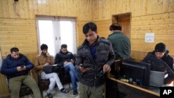 FILE - Kashmiri journalists browse the internet on their mobile phones inside the media center set up by government authorities in Srinagar, Indian controlled Kashmir, January 30, 2020.