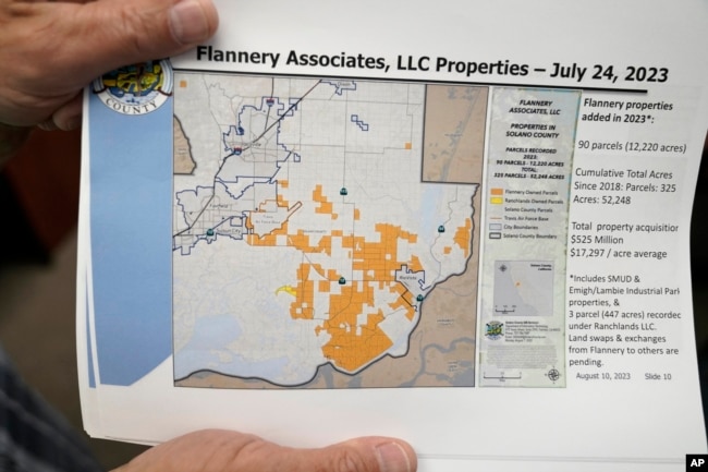 Mayor Ron Kott holds a map showing land acquisitions by Flannery Associates at City Hall in Rio Vista, Calif., Wednesday, Aug. 30, 2023. Silicon Valley billionaires and investors are behind a years-long, secretive land buying spree of more than 78 square miles (202 square kilometers) of farmland in Solano County with the goal of creating a new city. (AP Photo/Godofredo A. Vásquez)