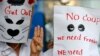Para demonstran anti-kudeta mengenakan topeng dari kantung kertas bertuliskan pesan anti-kudeta sambil mengacungkan salam &#39;tiga jari&#39; dalam aksi unjuk rasa di sebuah pusat perbelanjaan di Bangkok (1/6).
