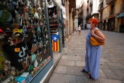 A woman looks at masks displayed at a souvenir shop, amid the coronavirus outbreak, in Barcelona, Spain, July 27, 2020.