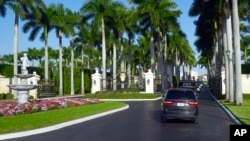 FILE - A motorcade with President Donald Trump drives into the Trump International Golf Club in West Palm Beach, Fla., Nov. 21, 2018. 