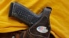 FILE - A man wears an unloaded pistol during a pro gun-rights rally in Austin, Texas, April 14, 2018. 