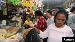 Seorang ibu rumah tangga membeli makanan di pasar yang ramai di Jakarta. Pakar pada 20 April 2021 mengatakan karena budaya dan kebijakan negara, masyarakat Indonesia masih memandang tugas rumah tangga bukan sebagai pekerjaan.(Foto: Reuters)