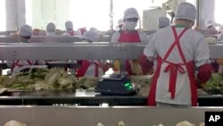 Workers prepare kimchi on the production line at the Ryugyong Kimchi Factory on the outskirts of Pyongyang, North Korea, Dec. 20, 2017. Using a strategy known as “byungjin,” Kim intends to simultaneously develop the national economy and North Korea’s nuclear weapons program.