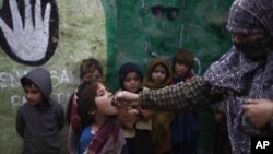 Seorang anak sekolah Pakistan tengah menerima vaksinasi polio dari petugas di pinggiran kota Islamabad, Pakistan (Foto: dok). Seorang polisi Pakistan ditembak mati saat melindungi tim vaksinasi polio di wilayah Waziristan, Selasa (26/2).