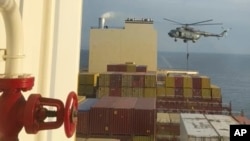 Кадр из видео с вертолетом, который зависает над торговым судном вблизи Ормузского пролива. 13 апреля 2024 года. (AP Photo)