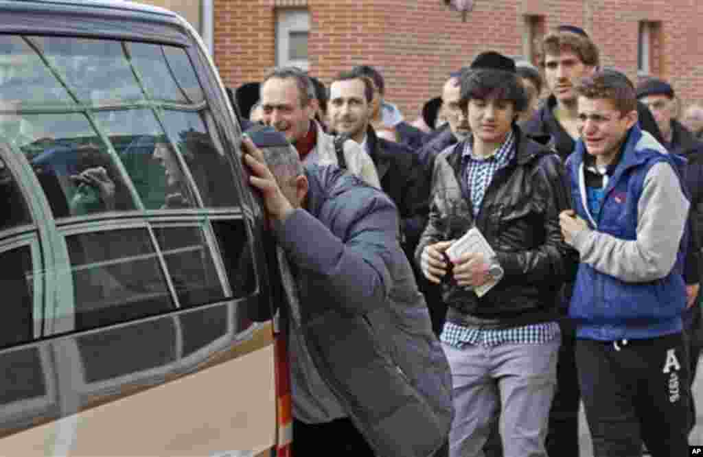 Mourners follow the hearse carrying the coffins of the victims following a ceremony at the Ozar Hatorah Jewish school where a gunman opened fire killing four people in Toulouse, southwestern France, Tuesday, March 20, 2012. A father and his two sons were