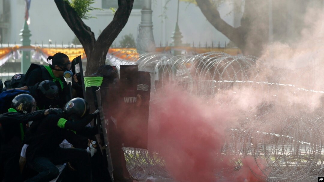 Polisi menembakkan gas air mata untuk menghentikan demonstran yang berbaris menuju kantor PM Prayuth Chan-ocha di Bangkok, Thailand hari Minggu (18/7). 