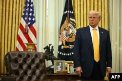 Presiden AS Donald Trump berdiri di belakang Resolute Desk selama upacara pelantikan Menteri Perdagangan AS Howard Lutnick di Ruang Oval Gedung Putih di Washington, DC, pada 21 Februari 2025. (Foto: AFP)