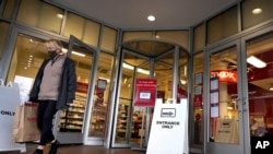 FILE - A shopper steps out of a department store, in Boston, Massachusetts, Oct. 27, 2020.