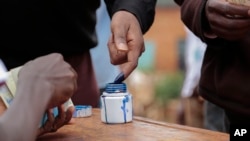 A Burundian official marks a voter's finger with ink after voting in parliamentary elections in Ngozi, Burundi, June 29, 2015. 