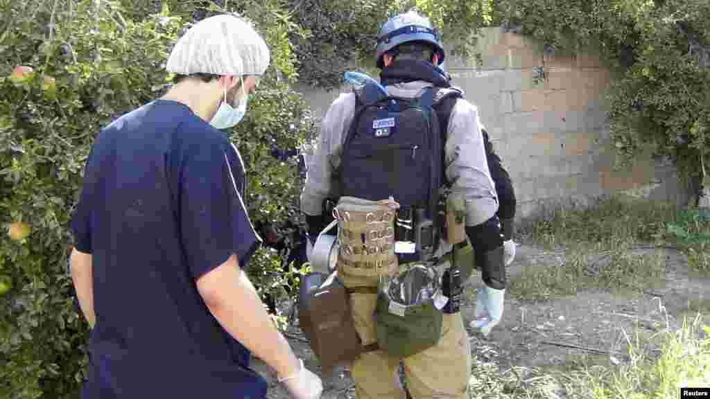 A U.N. chemical weapons expert gathers evidence at site of an alleged poison gas attack in a southwestern Damascus suburb, August 26, 2013. 