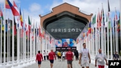 ARCHIVO -Participantes de los Juegos Olímpicos y Paralímpicos de París 2024 caminan frente a la cafetería de la Villa Olímpica, en Saint-Denis, al norte de París, el 22 de julio de 2024, antes de la ceremonia de apertura de los Juegos Olímpicos y Paralímpicos de París 2024.