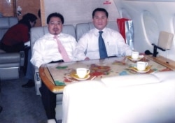 FILE - Former North Korean official, Ri Jong Ho, right, who oversaw North Korea's overall production and trade while serving at the Office 39 for decades, heads to Pyongyang with Chinese investment tycoon Sam Pa, December 2006.