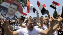 Protesters shout slogans, one of them holding a depiction of Syrian President Bashar al-Assad and a Syrian flag, during a demonstration in Beirut, Lebanon, Sunday, June 19, 2011