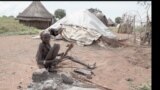 A woman struggles to roast sorghum for food at Naipuru camp for internal displaced persons in Jebel Boma County. (John Tanza/VOA)