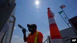 John Ford, a worker with the Port of Seattle, paints near a railing at the Bell Street Cruise Terminal at Pier 66, June 30, 2021, in downtown Seattle. 