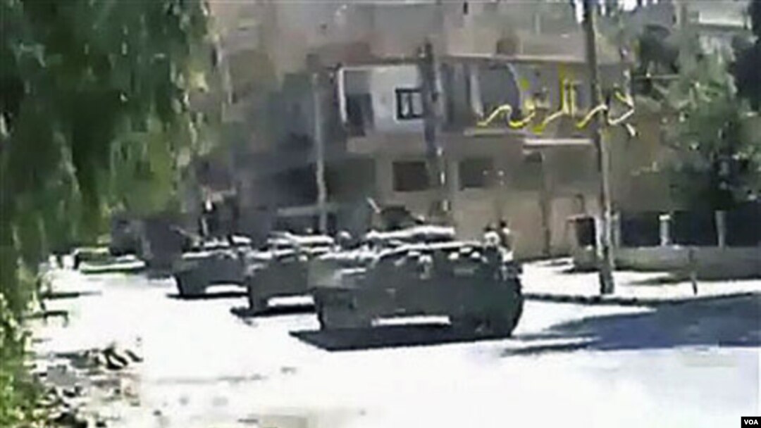 Gambar dari sebuah video amatir yang dikirim ke AP menunjukkan tank-tank tentara Suriah di jalanan kota Deir el-Zour, Selasa (9/8).
