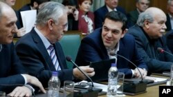 Greece's Prime Minister Alexis Tsipras, second right, and Deputy Prime Minister Giannis Dragasakis chat during the first cabinet meeting of the new government at the Parliament in Athens, on Wednesday, Jan. 28, 2015. (AP Photo/Petros Giannakouris)