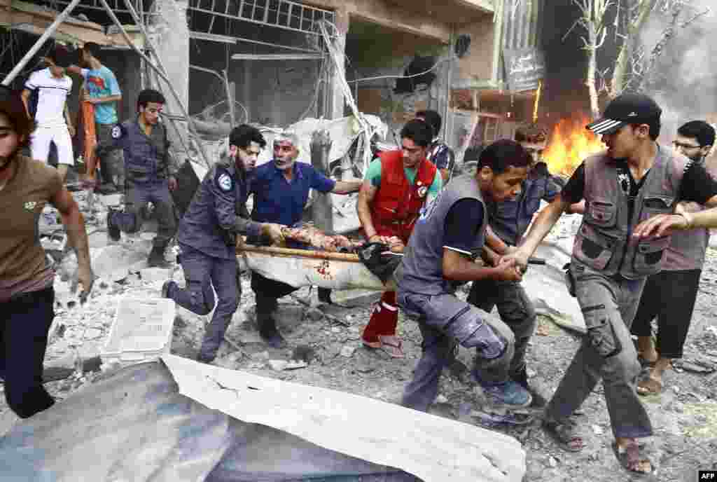Emergency services and civilians carry a serverely wounded man on a stretcher following an airstrike on Douma, a rebel-held suburb east of the Syrian capital Damascus.