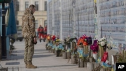 A serviceman mourns at the Memorial Wall of Fallen Defenders of Ukraine in Russian-Ukrainian War in Kyiv, Ukraine, Feb. 24, 2025.