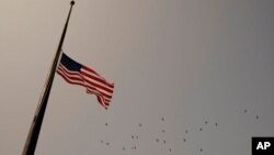 FILE - An American flag flies at half-staff.