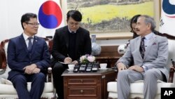 South Korean Unification Minister Kim Yeon Chul, left, meets with U.S. Ambassador to South Korea Harry Harris, right, during their meeting at a government complex in downtown Seoul, South Korea, Tuesday, April 16, 2019. (AP Photo/Lee Jin-man)