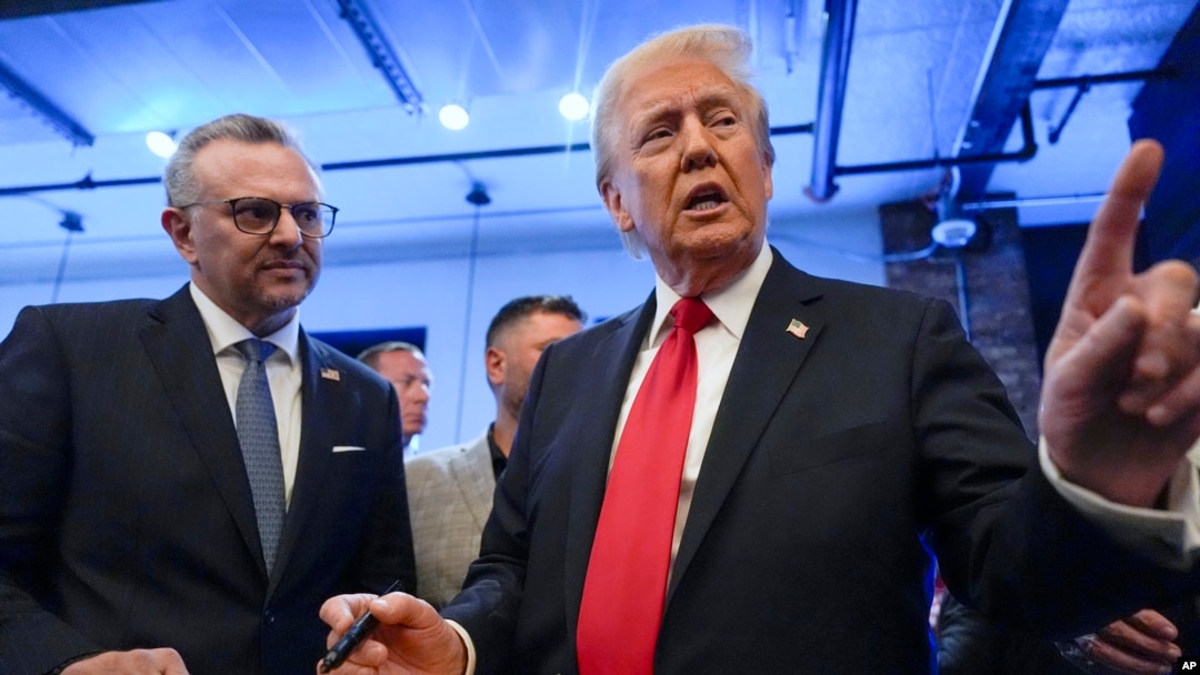 FILE - Republican presidential nominee former President Donald Trump signs autographs as Massad Boulos listens during an event in Dearborn, Michigan, Nov. 1, 2024.