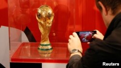 Seorang pria mengambil foto trofi Piala Dunia FIFA setelah konferensi pers FIFA World Cup Trophy Tour 2017 di Kasnoyarsk, Siberia, Rusia, 10 September 2017. ( REUTERS/Ilya Naymushin)