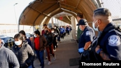 Migrantes expulsados de EE.UU. y enviados de regreso a México bajo el Título 42 caminan hacia México en el puente fronterizo internacional Paso del Norte, en Ciudad Juárez, el 19 de mayo de 2021.