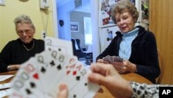 Beryl O'Connor (80) menikmati waktu luangnya bermain kartu dengan teman-temannya yang juga telah lanjut usia di rumahnya di New Jersey.