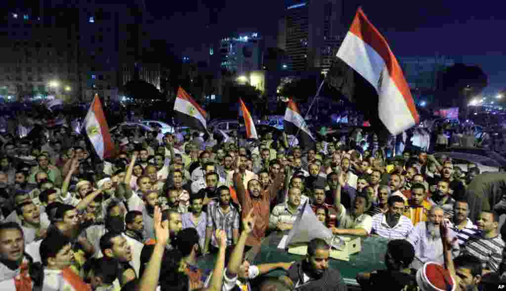 Morsi supporters listen to his speech on a microphone over a car in Tahrir Square.