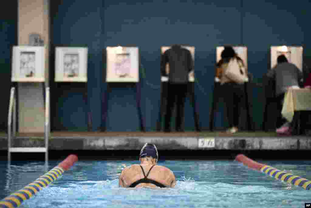 Sarah Salem, 34, swims as voters cast their ballots at Echo Deep Pool Tuesday, Nov. 6, 2018, in Los Angeles.